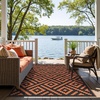 GENIMO Outdoor Rug for Patio Clearance, 5’x8′ Reversible Plastic Straw Rugs, Lightweight Waterproof RV Camping Mat for Camper, Balcony, Deck, Backyard, Picnic, BlackBrown(Black&orange)